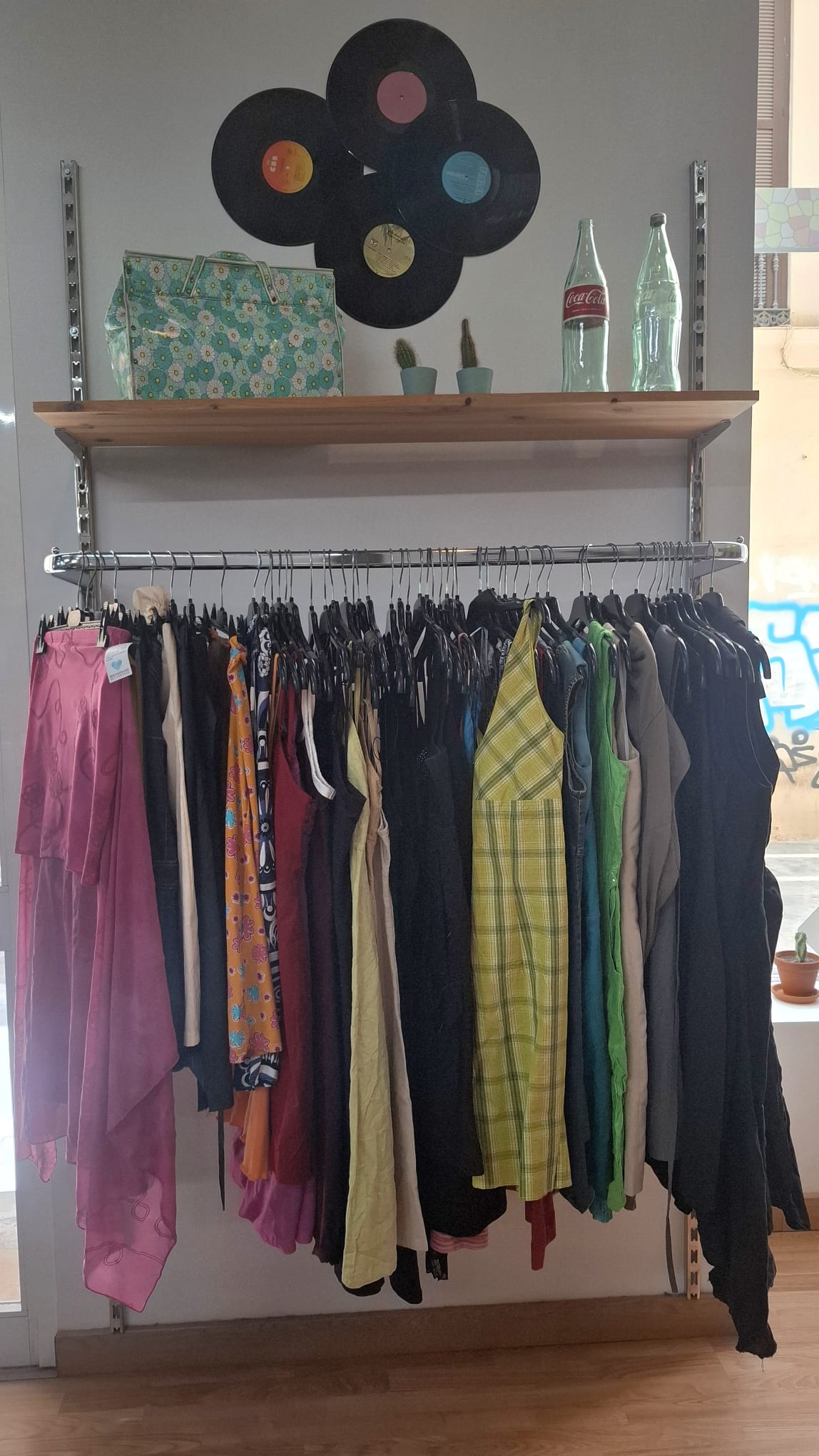 Kleiderstange mit bunter Vintage-Kleidung bei Mosaico Vintage in Málaga.